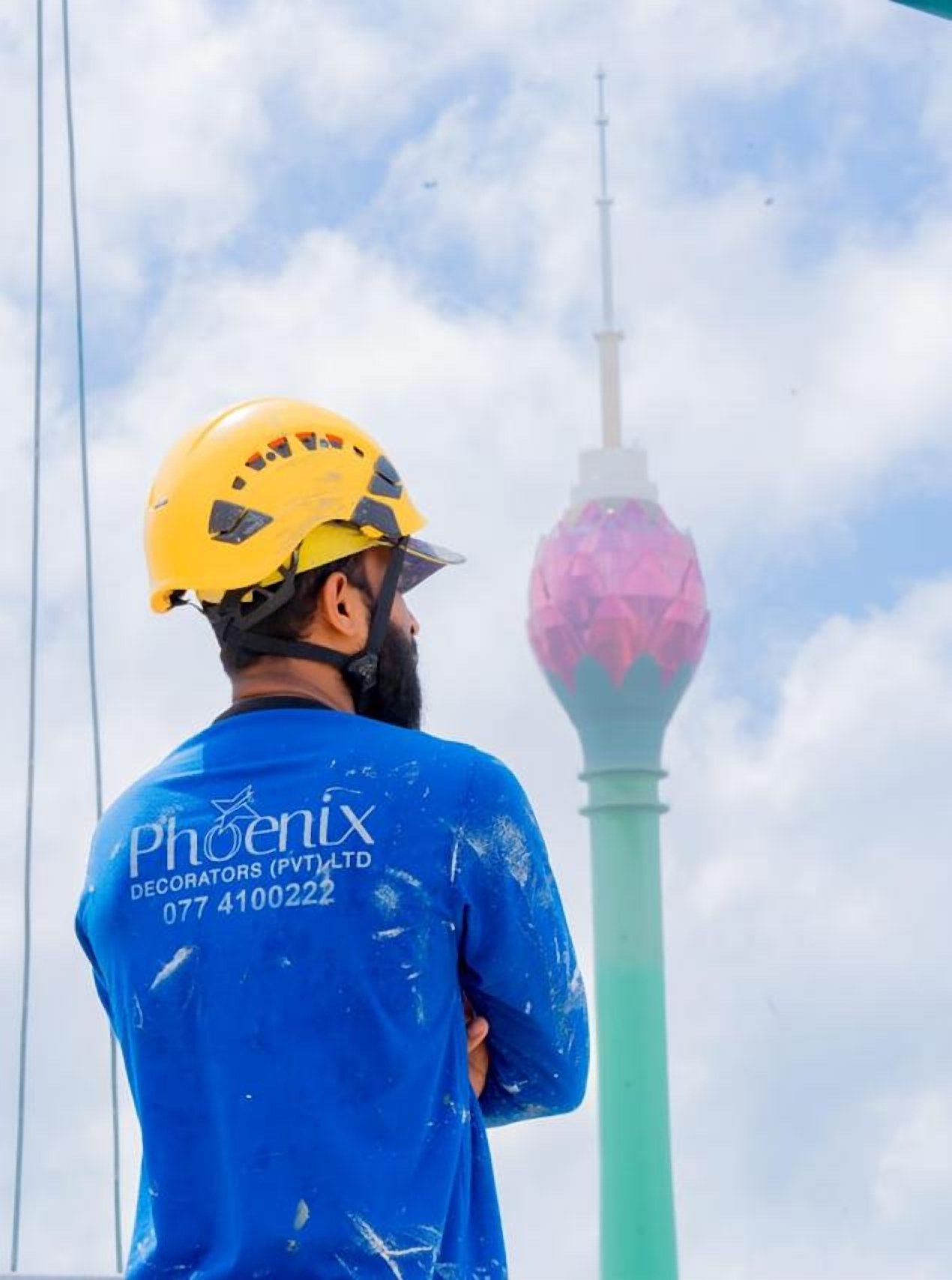 Phoenix technician in a branded shirt with the Lotus Tower behind