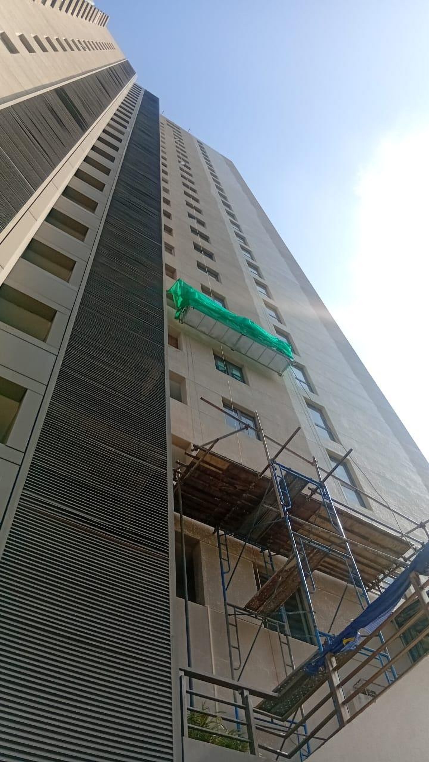 High-rise facade with a gondola and scaffolding in place