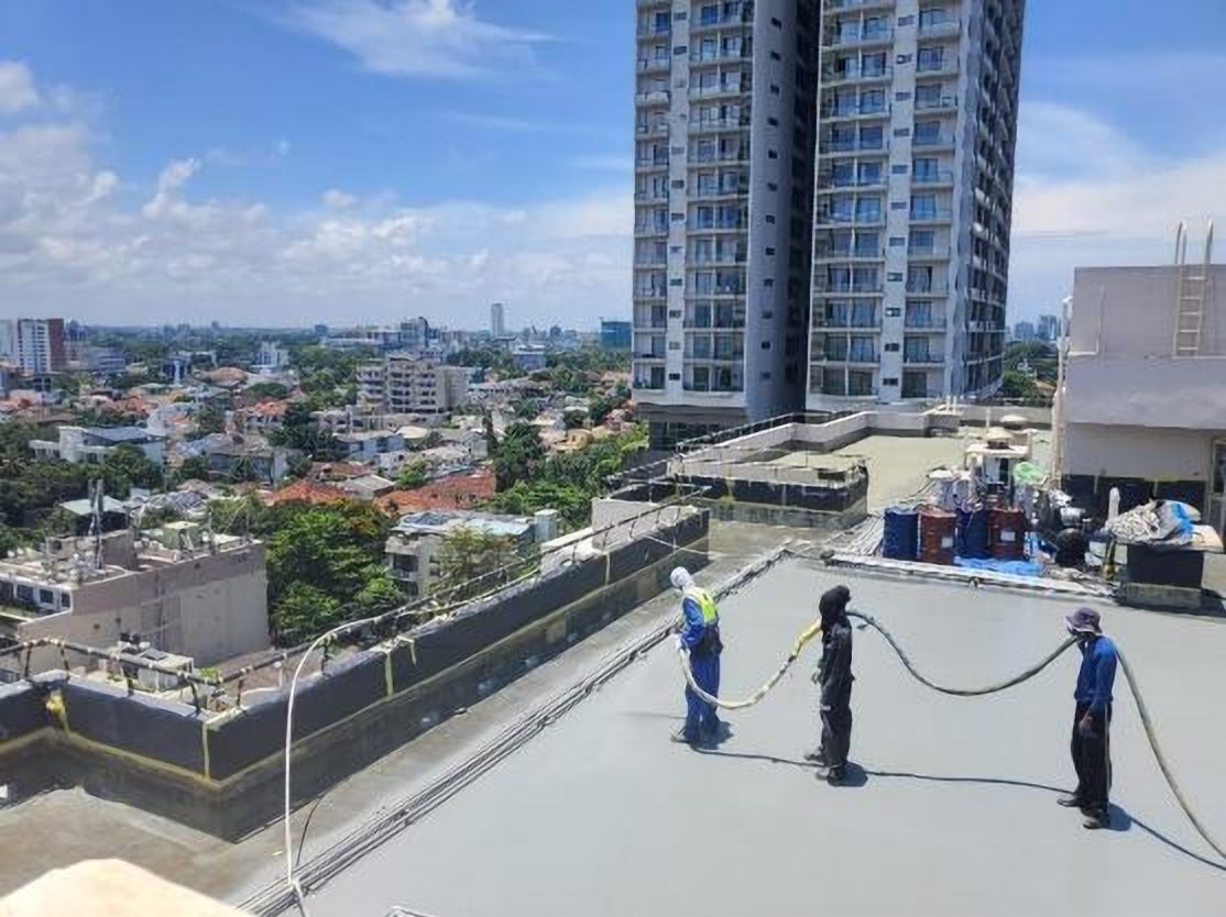 Rooftop waterproofing in progress with the Colombo skyline behind